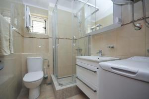 a bathroom with a toilet and a sink and a shower at Seaside Apartments Petrovac in Petrovac na Moru