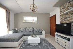 sala de estar con sofá y TV de pantalla plana en Seaside Apartments Petrovac, en Petrovac na Moru