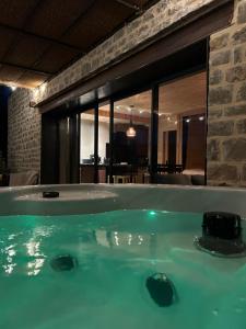 a jacuzzi tub in a room with a table at Lechappee des causses in Mostuéjouls