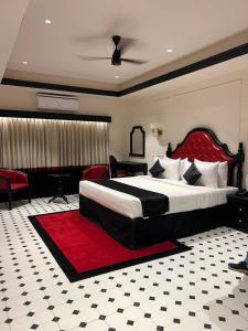 a bedroom with a large bed with a red headboard at Hotel Bengal Kutir in Rāiganj