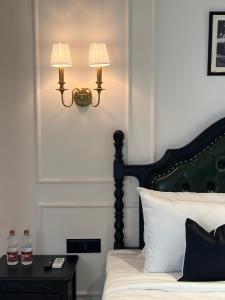 a bedroom with a bed with two lamps on the wall at Hotel Bengal Kutir in Rāiganj