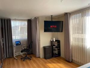 un salon avec une télévision au mur dans l'établissement The Chill Spot, à Arequipa