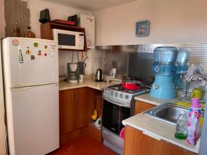 une cuisine avec un réfrigérateur blanc et un évier dans l'établissement The Chill Spot, à Arequipa