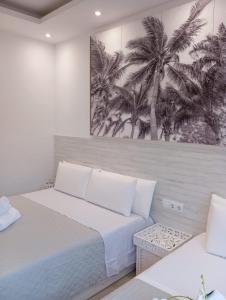 a bedroom with two beds and a picture of palm trees at Warm Harbor in Santa Coloma de Gramanet
