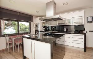 eine Küche mit weißen Schränken und einer Arbeitsplatte in der Unterkunft Pet Friendly Home In Santa Susanna in Santa Susanna