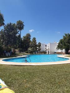 basen ze zjeżdżalnią w trawie w obiekcie Estepona Golf Apartment w mieście Estepona
