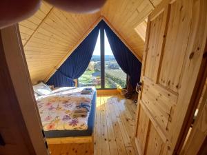 a bedroom with a bed in a room with a window at Świętokrzyskie Stodoły - Domek AJWO in Psary