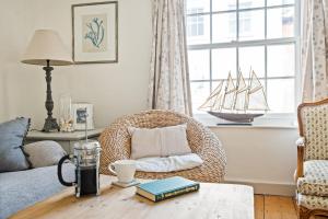 sala de estar con silla de mimbre y mesa en Central Lymington Retreat, en Lymington 16 fotos más