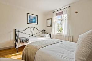 Un dormitorio con dos camas y una ventana. en Central Lymington Retreat, en Lymington