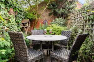 Una mesa y sillas en un jardín con copas de vino. en Central Lymington Retreat, en Lymington