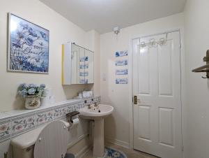 a white bathroom with a sink and a toilet at City Centre Vintage Theme Guest Rooms in Liverpool +34 photos
