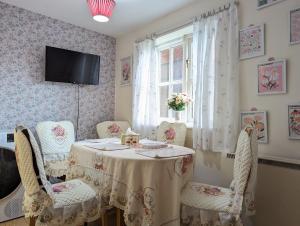 a dining room with a table and chairs and a window at City Centre Vintage Theme Guest Rooms in Liverpool