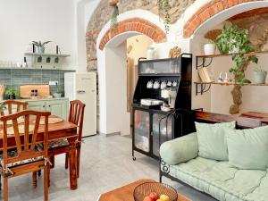Una cocina y una sala de estar con un sofá y una mesa. en Antica Dimora Polpenazze, en Polpenazze del Garda