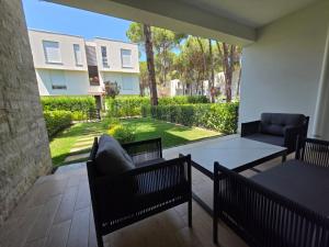 eine Terrasse mit 2 Stühlen, einem Tisch und einem Sofa in der Unterkunft Blue Harmony in Lalzit Bay + 4 Fotos