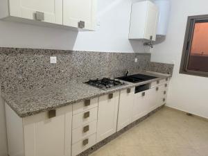 a kitchen with white cabinets and granite counter tops at Ciel&Azur in Sidi Ifni