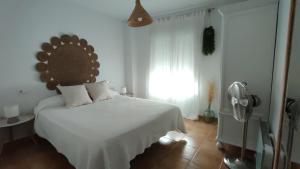 a bedroom with a white bed and a window at Azahares Apartamento turístico in El Bosque +58 photos