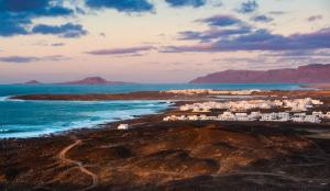 a group of white buildings on the shore of the ocean at Casa Brisa in La Santa