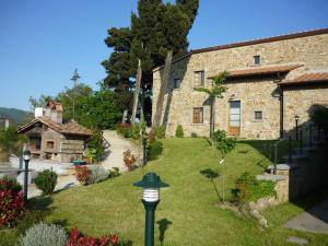 an old stone building with a garden and a bird house at Apartments in Barberino di Mugello 23852 in Montecarelli