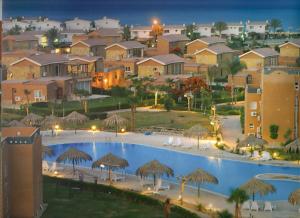 a large swimming pool with umbrellas and a resort at Florence Chalet in Marina Wadi Degla Ain Sokhna - Ground floor with 360 Sqm with Private Garden in Ain Sokhna