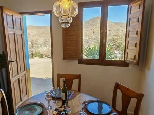 - une table à manger avec une bouteille de vin et des verres dans l'établissement Los Nopalitos 2 - Estudio chulísimo súper equipado a 3,5km de Carboneras, à El Llano de Don Antonio