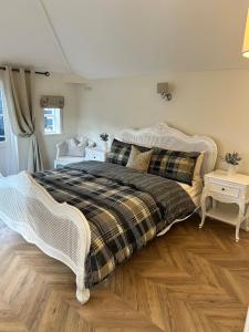a bedroom with a large bed with a white bed frame at Historic Retreat Near To Mersea Island in Peldon