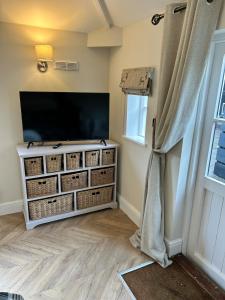 a living room with a flat screen tv and a window at Historic Retreat Near To Mersea Island in Peldon +19 photos