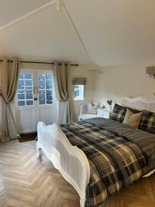 a bedroom with a large bed and a window at Historic Retreat Near To Mersea Island in Peldon