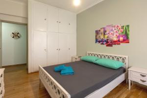 a bedroom with a bed with green and blue pillows at Athens center traditional & classic 2BR apartment in Mesochórion