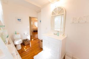 a white bathroom with a sink and a toilet at The Cottage House in Thompson +24 photos