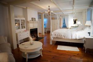 a white bedroom with a bed and a fireplace at The Cottage House in Thompson