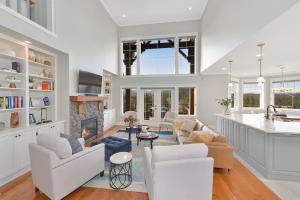 a living room with white furniture and a fireplace at Mount Finlayson View Villa by EMR Vacation Rentals in Victoria