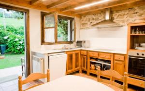a kitchen with wooden cabinets and a counter top at Casa del Tesoro II in Cangas de Onís +9 photos