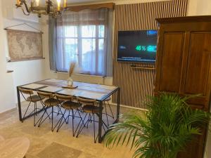 a dining room with a table and chairs and a tv at Le Clos des Papes in Avignon