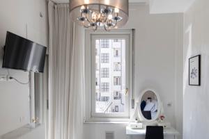 a room with a window with a mirror and a chandelier at The Gallery Boutique Rooms in Trieste