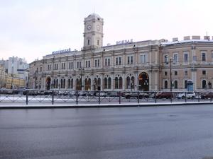 un grande edificio con una torre dell'orologio sopra di Apartment v novom dome on Kremenchugskaya 13 a San Pietroburgo