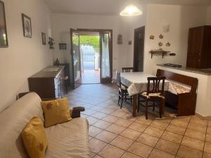 Una sala de estar con un sofá y una mesa y una cocina. en Domeddas - Domedda Enrico, en Posada