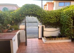 Un jardín al aire libre con una puerta arqueada y plantas. en Domeddas - Domedda Enrico, en Posada