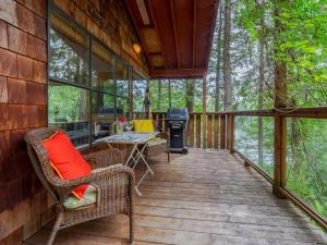 une véranda couverte avec des chaises et un grill dans l'établissement The Lakeside Cottage, à Gibsons