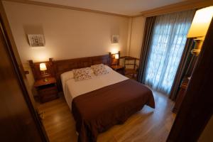 a hotel room with a bed and a window at Hotel Edelweiss in Camprodon