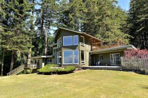 a house with a large yard in front of it at Pacific Coast Beach House by EMR Vacation Rentals in Sooke