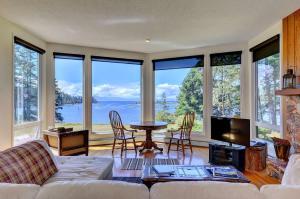 a living room with a couch and a table with chairs at Pacific Coast Beach House in Sooke