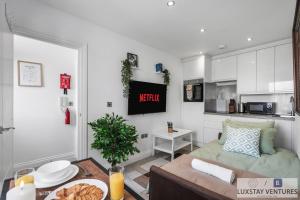 a living room with a couch and a kitchen at City Centre - Top Floor Luxury Apartment - Free Secure Small Car Parking - 5 Minute Walk to Beach & Station in Brighton & Hove