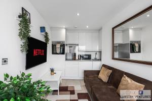 a living room with a couch and a kitchen at City Centre - Top Floor Luxury Apartment - Free Secure Small Car Parking - 5 Minute Walk to Beach & Station in Brighton & Hove