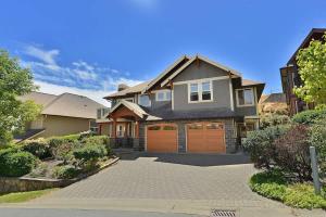a house with two garage doors on a driveway at Nature's Gate Executive Estate by EMR Vacation Rentals in Victoria