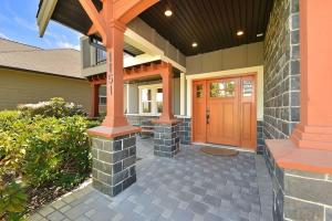 a front porch of a home with a wooden door at Nature's Gate Executive Estate by EMR Vacation Rentals in Victoria