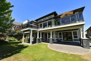 a large house with a balcony on top of a yard at Nature's Gate Executive Estate by EMR Vacation Rentals in Victoria