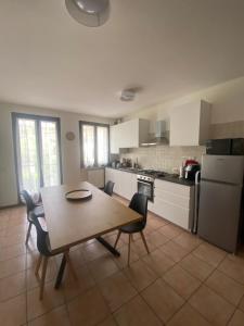 a kitchen with a wooden table and chairs and a table and a table at Gardasweethome in Garda