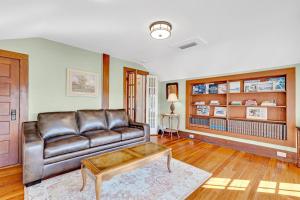 ein Wohnzimmer mit einem Ledersofa und einem Couchtisch in der Unterkunft St Augustine "Pink House" Sleep 12, 6 Bd, 3Bth, Steps to Historic St Augustine Center & All Tourist Attractions, Restaurants, Cafes, Backyard, Porch in St. Augustine