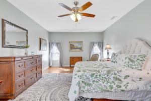ein Schlafzimmer mit Bett und Deckenventilator in der Unterkunft St Augustine "Pink House" Sleep 12, 6 Bd, 3Bth, Steps to Historic St Augustine Center & All Tourist Attractions, Restaurants, Cafes, Backyard, Porch in St. Augustine