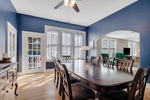 ein Esszimmer mit einem großen Holztisch und blauen Wänden in der Unterkunft St Augustine "Pink House" Sleep 12, 6 Bd, 3Bth, Steps to Historic St Augustine Center & All Tourist Attractions, Restaurants, Cafes, Backyard, Porch in St. Augustine